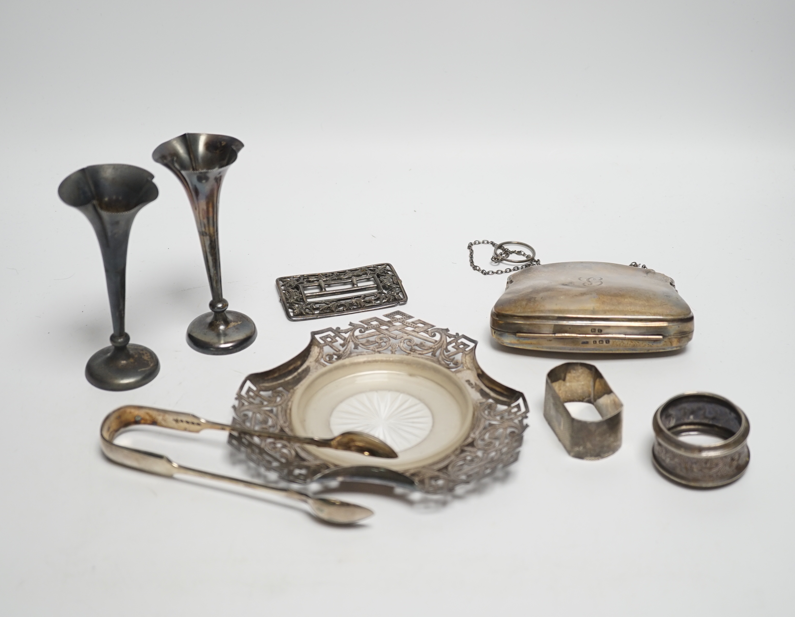 A pair of Edwardian silver mounted posy vases, Birmingham, 1902, weighted, 11.1cm, a silver purse, two silver napkin rings, silver butter dish stand, a silver belt buckle and a pair of plated sugar tongs.